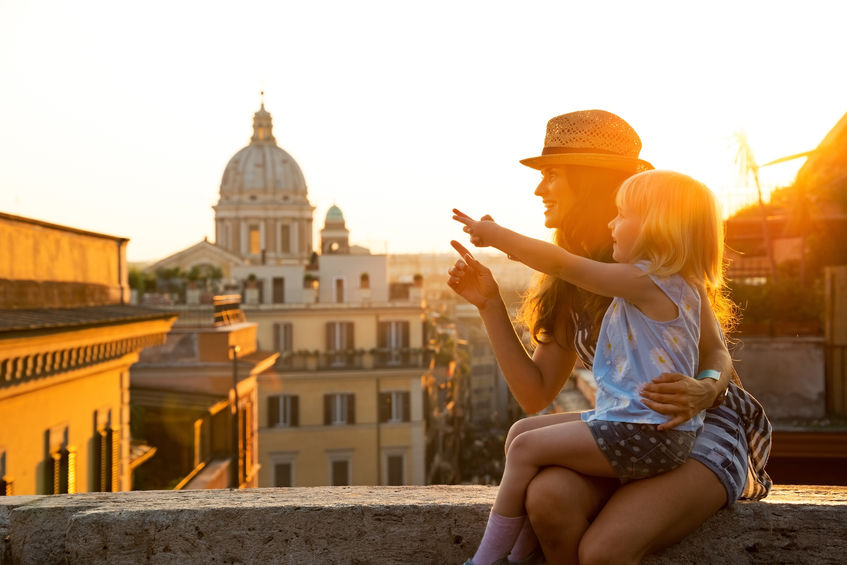 Mother and baby girl overlooking rooftops of Rome on sunset