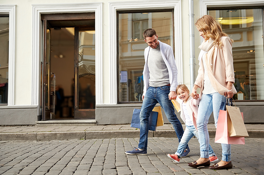 happy family with child and shopping bags in city