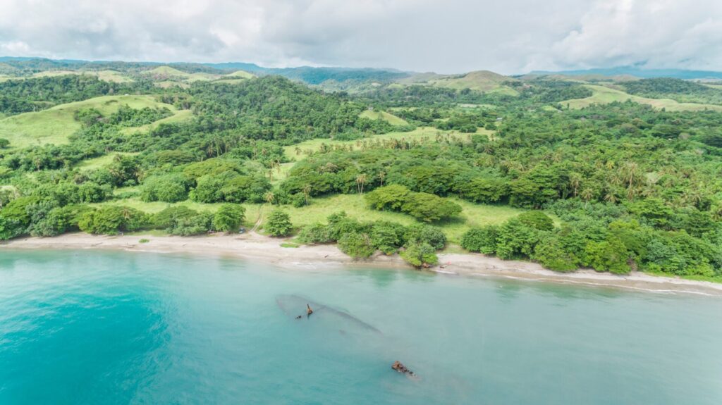 Arial view: Pacific Island beach, turquoise waters, white sands, lush greenery