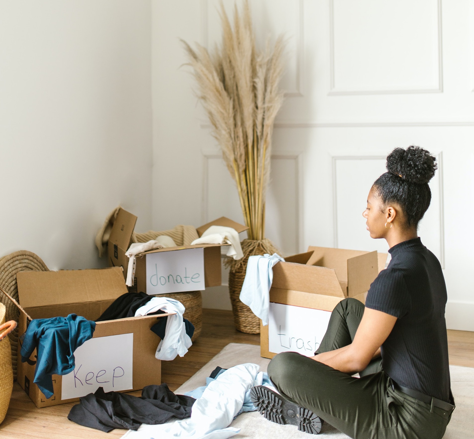 Woman sitting in front of donation boxes, sorting and organizing items