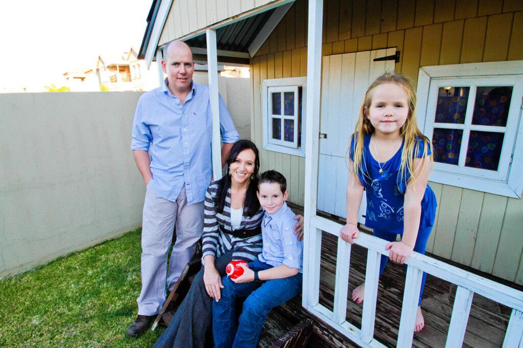Family with children in front of a cubby house.