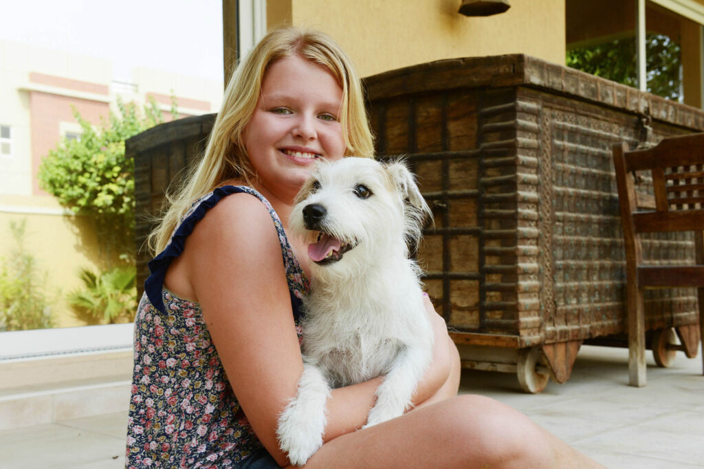 Child holding a pet dog