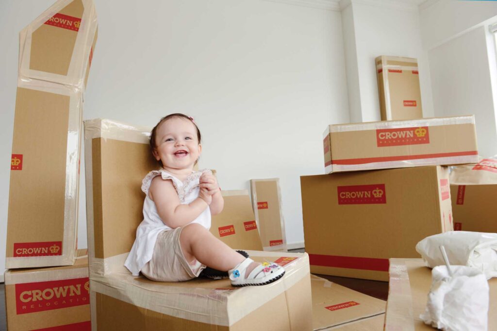 toddler sitting on packing boxes